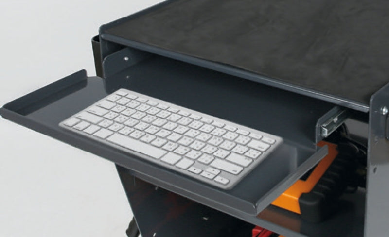 Keyboard tray attached to a piece of furniture with a keyboard on it.