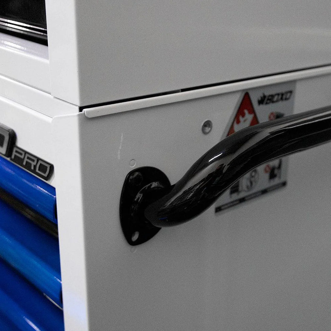 Close-up of a white toolbox with a black handle and visible brand logo.