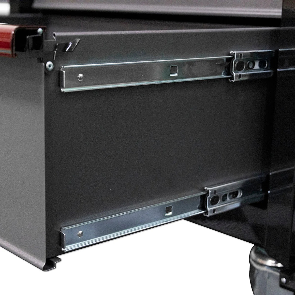 Close-up of a black cabinet with a visible hinge and metal components.