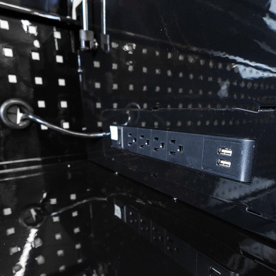 Close-up of a power strip with multiple outlets on a reflective black surface