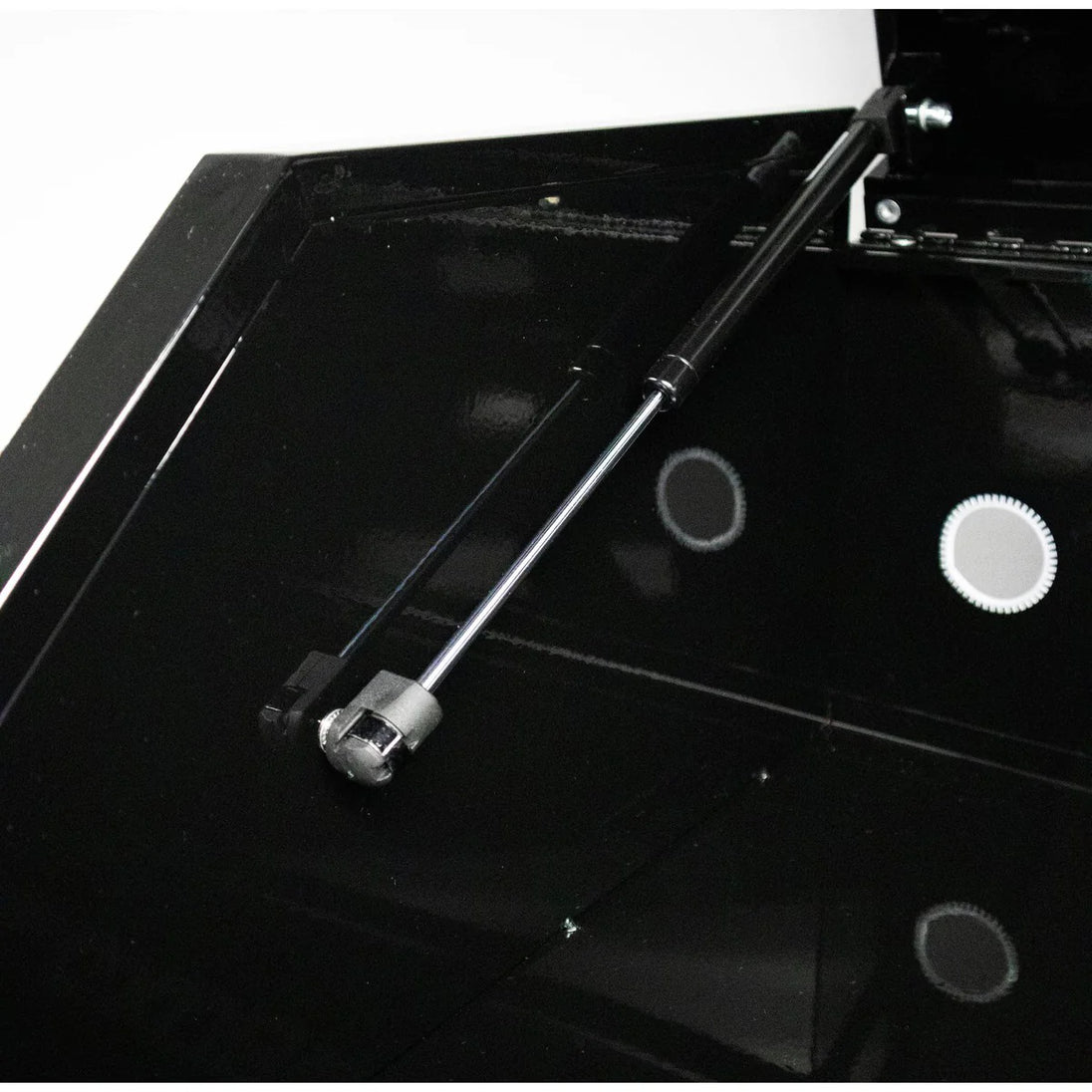 Black metal tool on a black surface with a white background
