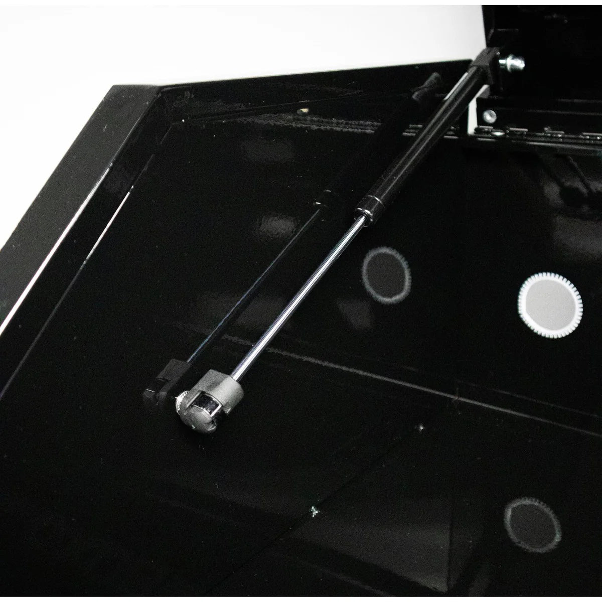 Black metal tool on a black surface with a white background