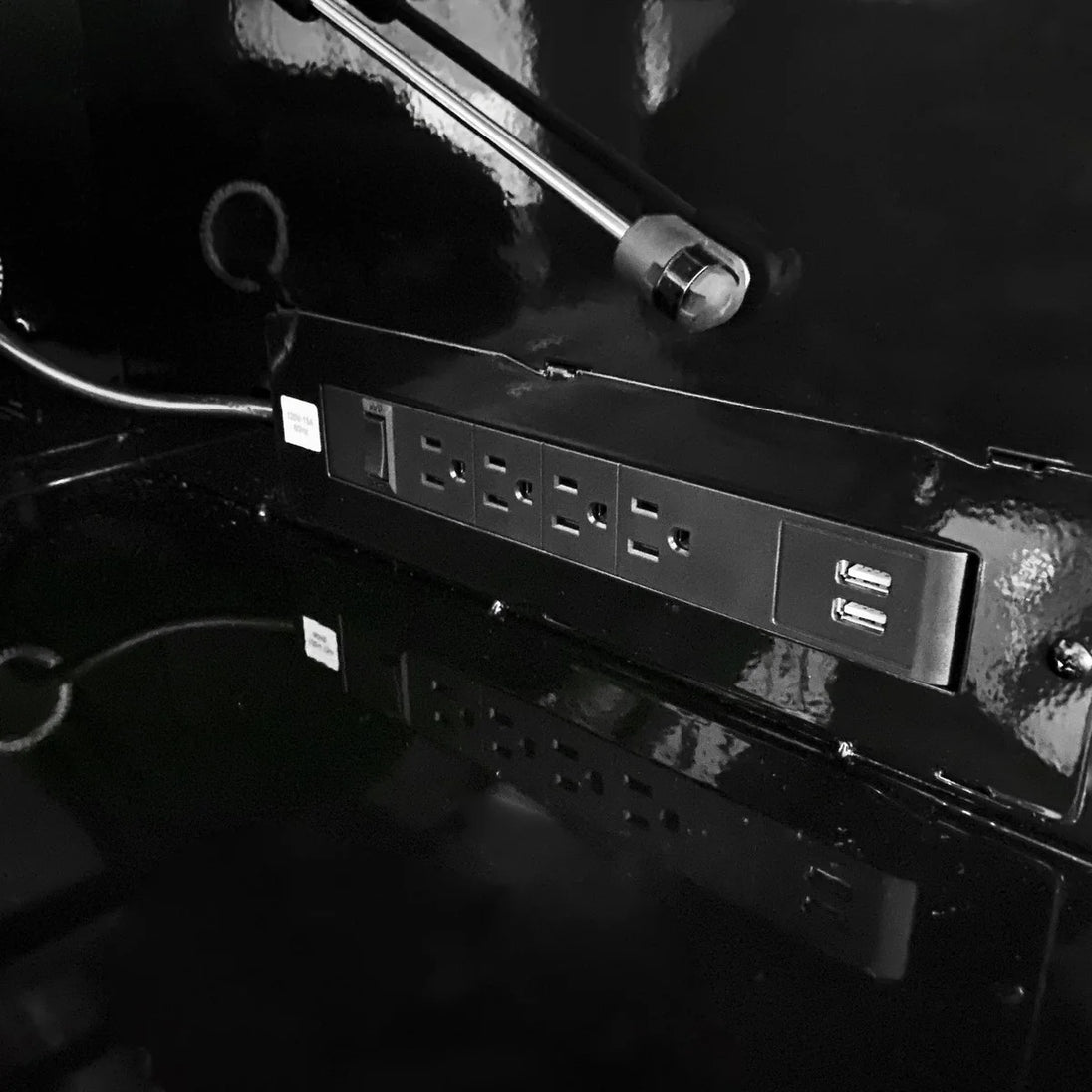 Close-up of a power strip with multiple outlets and USB ports on a dark background