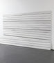 White wooden slatwall panel against a white wall