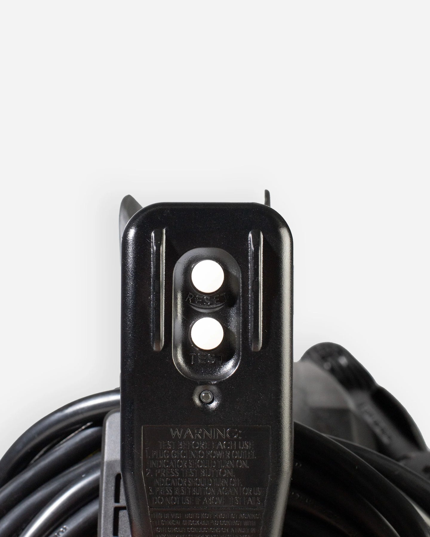 Close-up of a black electrical outlet adapter with a coiled black power cord against a light gray background.