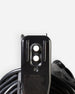 Close-up of a black electrical outlet adapter with a coiled black power cord against a light gray background.
