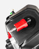 Close-up of a red plastic push-button connector with a silver metal tip mounted on a black device, shown against a light gray background.