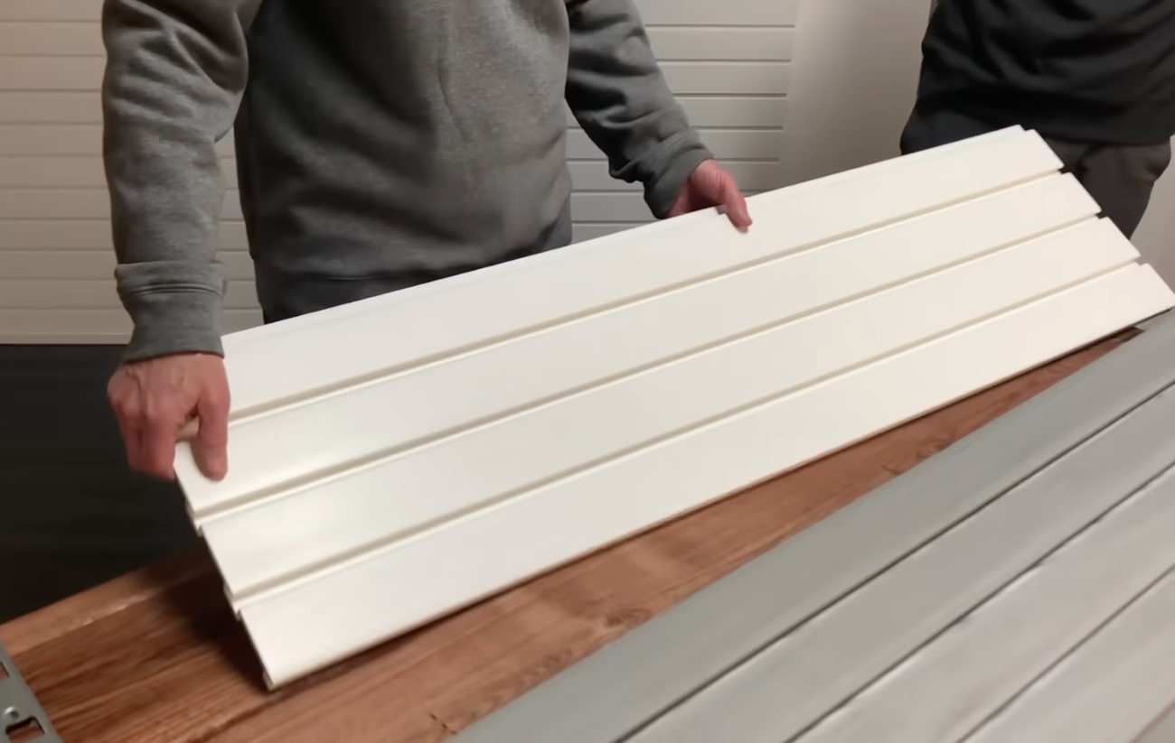 a man holding slatwall panel